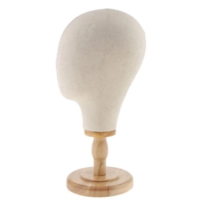 Detailed view of beige canvas mannequin head with professional round wooden base stand