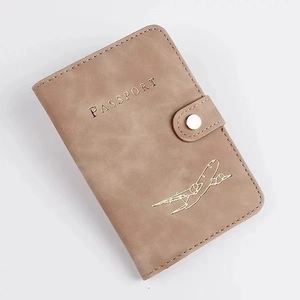 Close-up of light brown PU leather RFID passport cover with button and plane icon