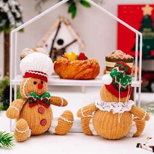 Detail of knitted gingerbread man plush dolls in a cozy Christmas scene setup