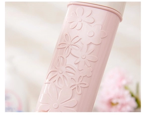 Detailed macro view of the pink portable toothbrush case with intricate floral embossing