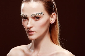 Close-up of model wearing elegant round purple crystal stud earrings with silver prongs