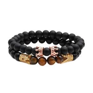 Ensemble de bracelets en perles œil de tigre et noir mat avec couronnes dorées sur blanc