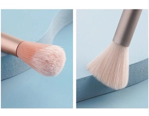 Detailed view of pink bristles and rose gold handle on a fluffy makeup brush