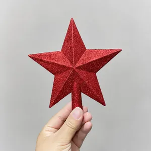 Close-up of a red glittered star tree topper held in hand with a secure socket base