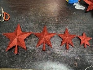 Detail of red glitter star Christmas tree toppers in various sizes with base poles