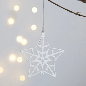 Flat iron star Christmas ornament hanging on tree branch with bokeh light background