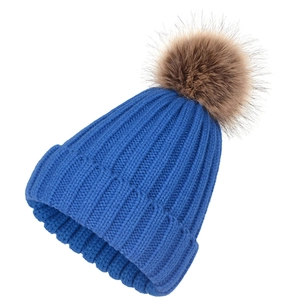 Detailed close-up of blue knit beanie with a fluffy brown faux fur pompom on white background