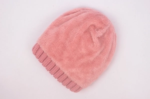 Detail of pink knitted beanie with soft faux fur texture and ribbed cuff design