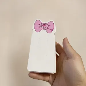 Close-up of pink bow design paper display cards for hair clips stacked in warehouse