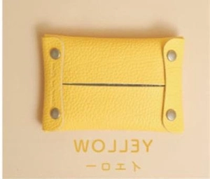 Detail of yellow lychee grain leather mini organizer pouch with metallic snap fasteners
