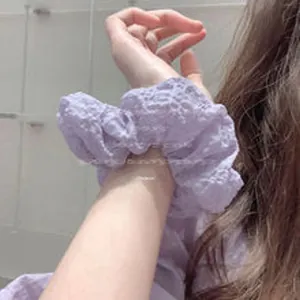 Dettaglio di un elastico per capelli in tessuto arricciato viola ad alta elasticità
