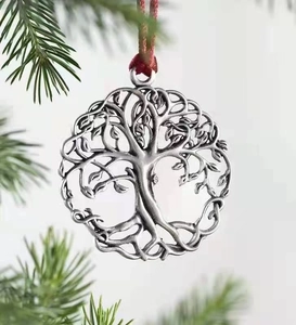 Close-up of vintage silver Tree of Life metal ornament hanging on a green pine branch