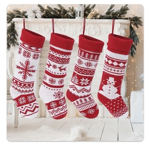 Close-up of knit Christmas stockings with snowflake and reindeer patterns on a mantel