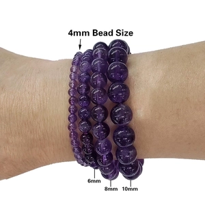 Natural amethyst beaded bracelets in 4mm to 10mm sizes shown on a female wrist