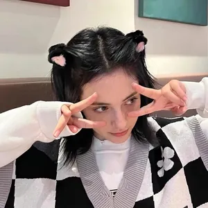 Close-up of a young woman wearing cute plush cat ear hair clips in a casual indoor setting