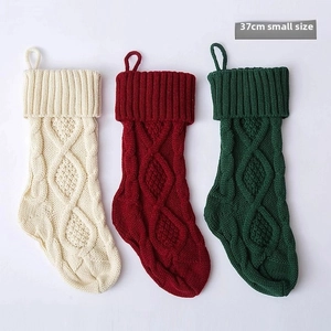 Detail of 37cm knitted Christmas stockings in cream, red, and green with cable stitch