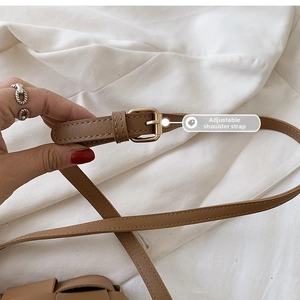 Detailed macro view of adjustable brown PU leather shoulder strap with gold metal buckle