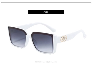 Close-up of white frame sunglasses with gradient grey lenses and golden temple detail
