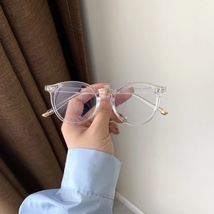 Detailaufnahme der transparenten runden Brille mit eleganten goldenen Metallakzenten