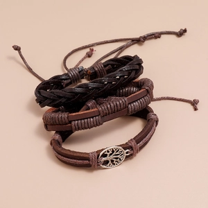 Detailed close-up of handmade vintage brown leather bracelets with tree of life charm