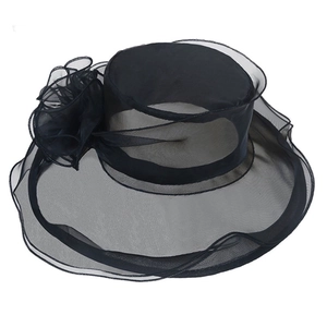 Detail of elegant black mesh sun hat featuring a delicate floral applique and wide brim
