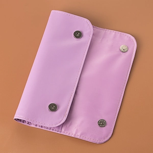 Close-up of a purple makeup brush travel case featuring dual magnetic metal buckles