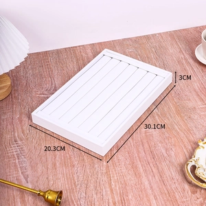 Detailed view of white jewelry display tray showing dimensions 30.1x20.3x3cm on wood desk