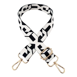 Adjustable black and white geometric woven bag strap with golden metal hardware