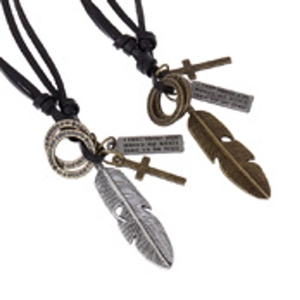 Detail of vintage leather necklaces featuring feather, cross and engraved metal charms