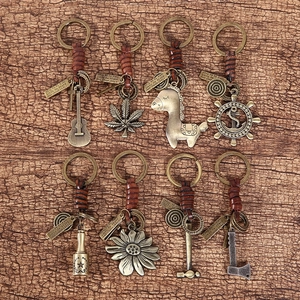 Detailed close-up of vintage leather keychains with bronze pendants on wood