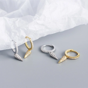 Detail of gold and silver S925 sterling silver hoop earrings with zircon cone pendants