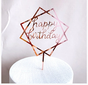 Close-up of rose gold acrylic Happy Birthday cake topper with geometric design