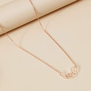Detailed view of rose gold stethoscope and heartbeat pendant necklace on display
