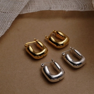 Detailed close-up of 925 sterling silver U-shaped hoop earrings in gold and silver finish