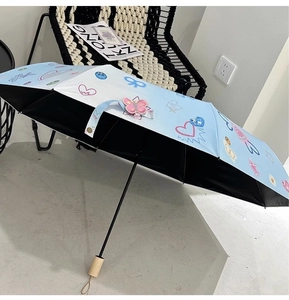Close-up of light blue parasol with graffiti heart patterns and a natural wooden handle