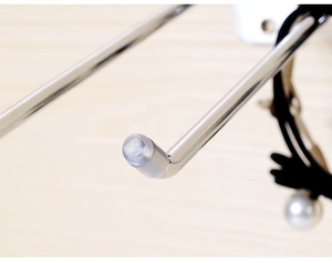 Detailed close-up of a metal slatwall hook featuring a clear protective tip for accessory display