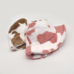 Detail of plush cow print bucket hats in brown and pink showing soft fuzzy texture