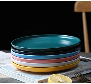 Close-up of stacked matte ceramic plates in multiple colors for Nordic dining style