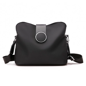 Classic black nylon crossbody bag with adjustable wide strap and round metal buckle