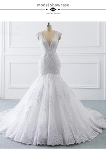 Detailed close-up of luxurious white lace floral embroidery and sequins on mermaid gown