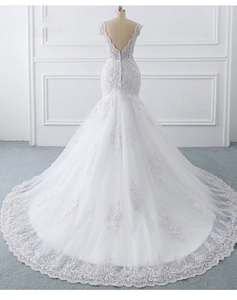 Close-up of white mermaid bridal gown with lace embroidery and long decorative train