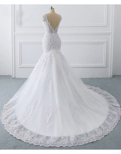 Detail of mermaid wedding dress with open back and lace train featuring satin buttons