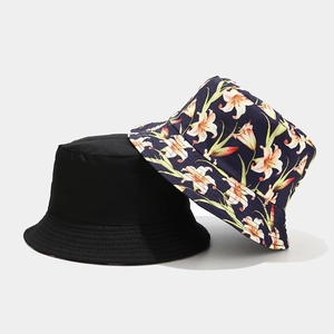 Detail showing reversible bucket hat with black side and floral pattern for sun protection
