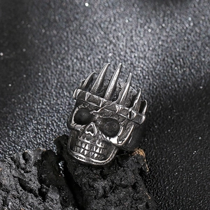 Gothic skull ring for men with crown spikes on dark rock background, rock style design