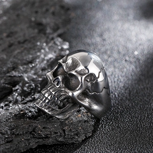 Close-up of rock style stainless steel skull ring with vintage finish on dark stone