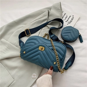 Close-up of blue quilted leather bag with golden twist-lock and matching round coin purse
