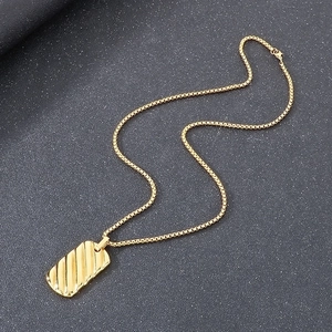 Detailed view of the 18k gold plated geometric bar pendant with textured diagonal lines