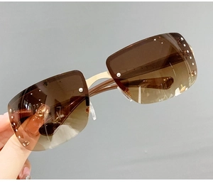 Detailed close-up of rimless rhinestone sunglasses with brown gradient lenses and gold bridge