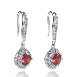 Macro detail of silver halo earrings with square red zircon stones and pavé diamonds