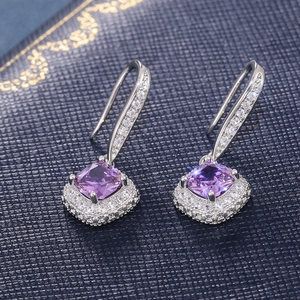 Macro detail of cushion cut purple gemstone earrings with halo pavé micro-inlay stones
